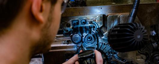 Der 23-jährige Werkzeugmechaniker Michael Breuer setzt eine Form mit zwei Kavitäten instand. / © Andreas Bednareck