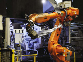 Ein Industrieroboter entnimmt einer Druckgießanlage ein Strukturbauteil. Rheinmetall erhält einen Großauftrag über 60 Millionen Euro.