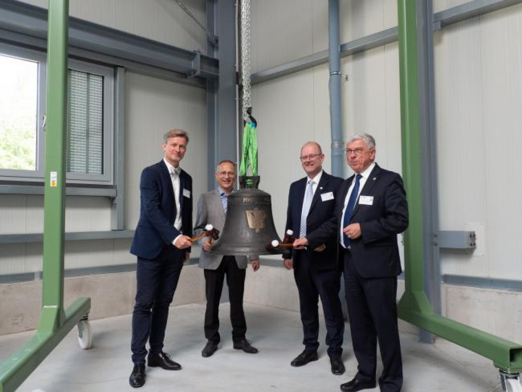 Staatssekretär Dr. Andreas Handschuh, Kanzler Jens Then, Prof. Gotthard Wolf und Rektor Prof. Klaus-Dieter Barbknecht eröffnen das Zentrum für klimaneutrale metallurgische Thermoprozesse mit einem Glockenschlag. (v.l.n.r.) - © TU FREIBERG Staatssekretär Dr. Andreas Handschuh, Kanzler Jens Then, Prof. Gotthard Wolf und Rektor Prof. Klaus-Dieter Barbknecht eröffnen das Zentrum für klimaneutrale metallurgische Thermoprozesse mit einem Glockenschlag. (v.l.n.r.) - © TU FREIBERG